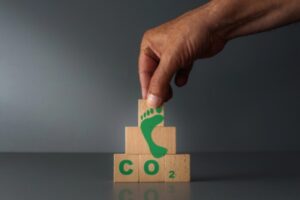 concept of carbon footprint with wooden puzzle with green footprint and CO2 text
