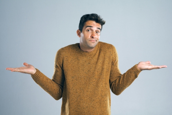 shrugging man wearing brown sweater depicting How Advanced High-Efficiency Heating Systems Operate
