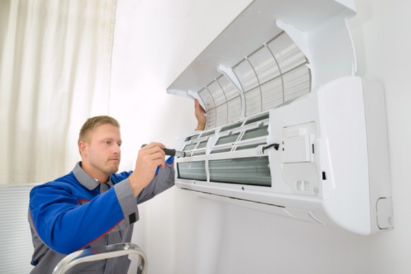 Professional HVAC technician tending to a ductless mini split