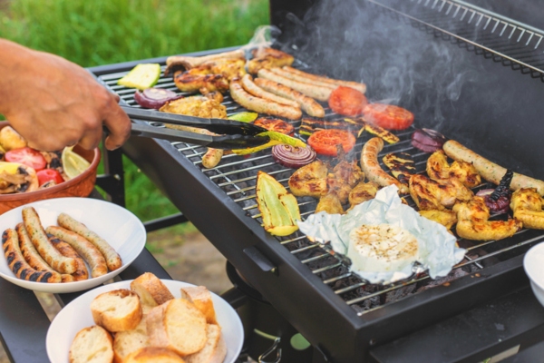 Grilling sausages and vegetables at home for a party