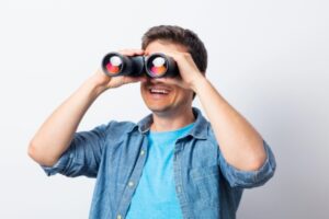 Young man seeking with binocular depicting what to look for in an HVAC contractor