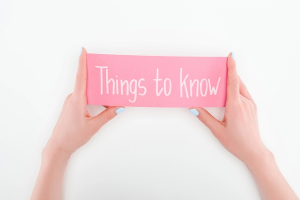 woman holding pink card that says things to know depicting essential tips for home energy conservation