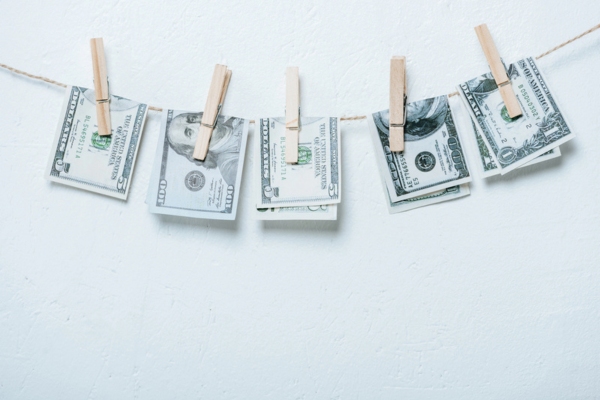Dollar banknotes hanging on rope depicting cost implications of partial AC replacement