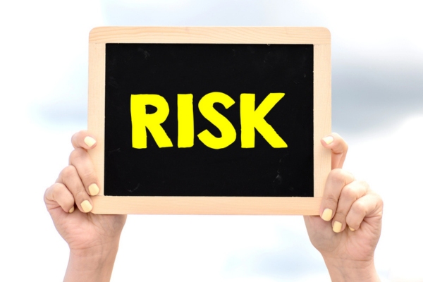 risk written on a mini chalkboard held up by hand depicting overlooking leaky air ducts