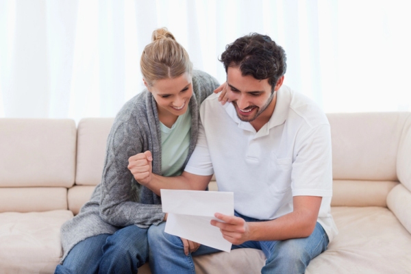 couple feeling happy while looking at energy bill due to lower expenses