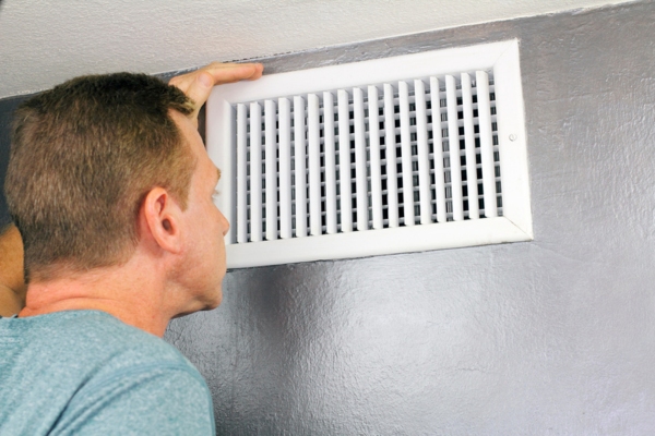 homeowner checking HVAC vent