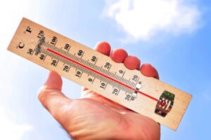 thermometer against blue sky depicting summer heat