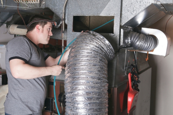 HVAC technician fixing ductwork due to wear & tear