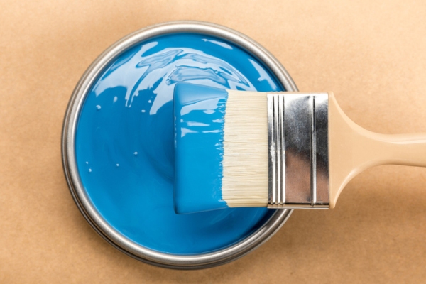 Top view of tin with blue paint and brush