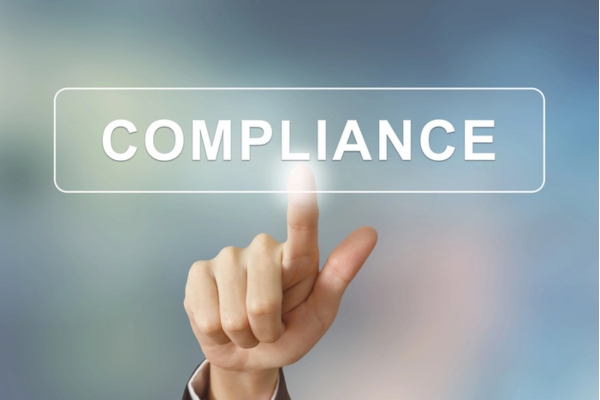 hand clicking compliance button on blurred background depicting propane tank