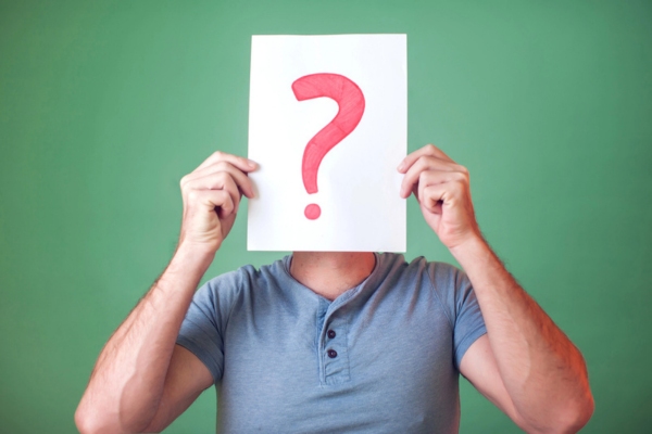 man holding question mark sign up his face depicting FAQs about Oil Tank Replacement