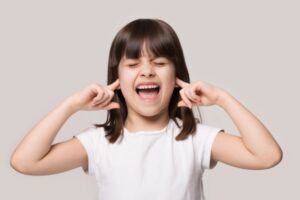 kid covering ears due to furnace sounds