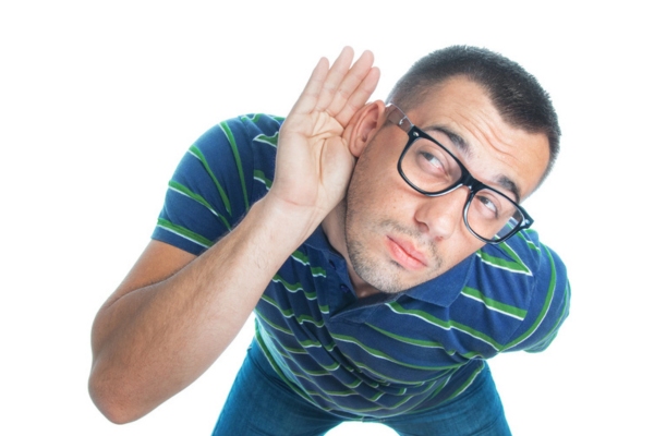 man looking up while cupping right ear listening to furnace sounds