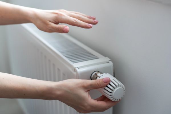 homeowner adjusting radiator thermostat