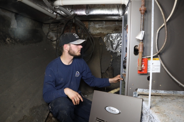 HVAC professional from Lake Region Energy examining a furnace
