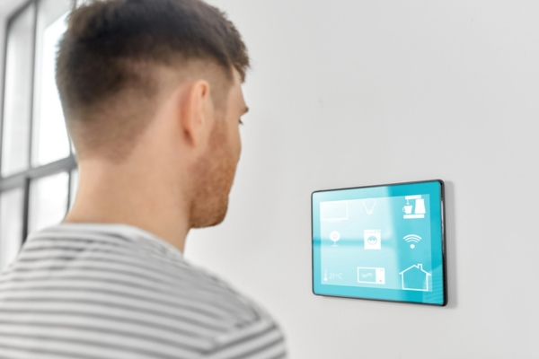 man looking at smart home thermostat control