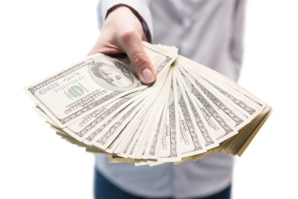 man's hand holding a stack of cash