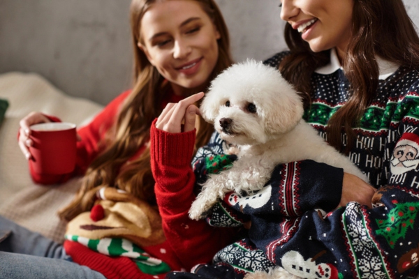 two girls sitting on the couch with their white dog depicting Steady, Efficient Warmth