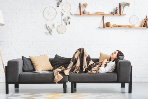 woman lying on the couch feeling warm and cozy