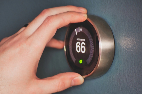 homeowner adjusting home thermostat