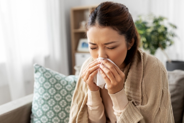 woman sneezing while indoors due to allergies