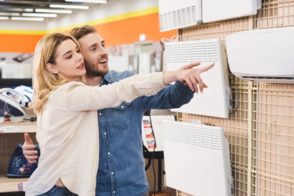 couple pointing towards a unit while air conditioning shopping