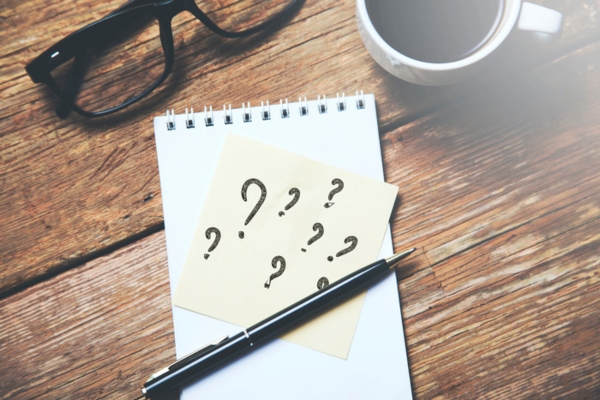 question marks written on a sticky note depicting How Does A Programmable Thermostat Work FAQs