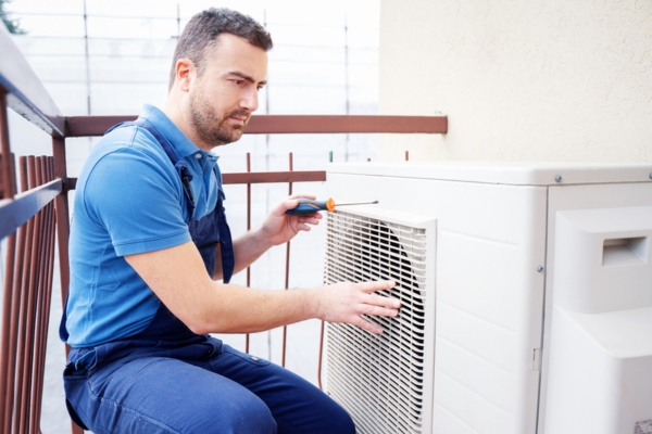 HVAC technician performing AC inspection