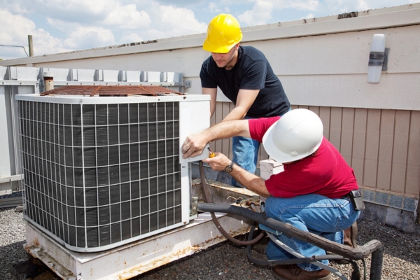 HVAC technicians tending to an air conditioner unit