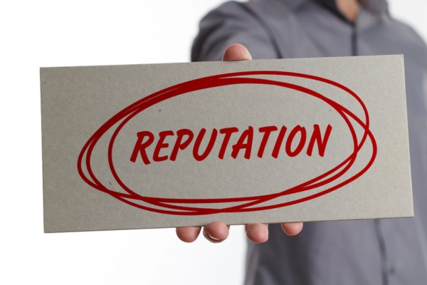 REPUTATION written on a board held by a man