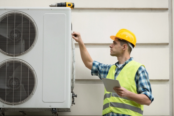 Technician worker tending to an Air Conditioning Unit