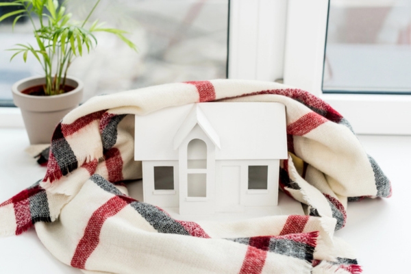 miniature house model wrapped in scarf depicting Heating Oil's Dependability