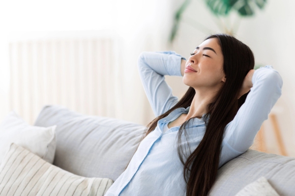 relaxed woman lounging on the couch depicting good indoor air quality