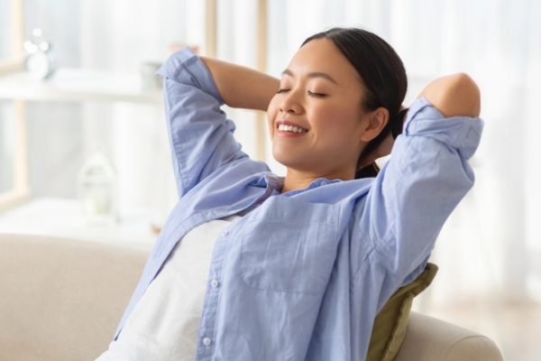 woman relaxing on the couch depicting Long-Term Value And Confidence With Heating Oil