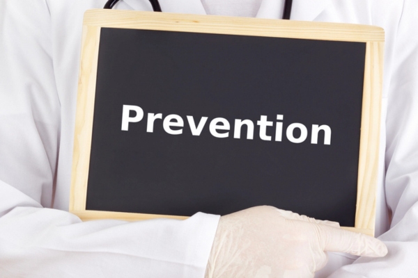 doctor holding a mini chalkboard with PREVENTION written on it