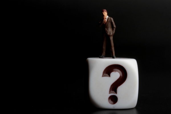 miniature person figure on top of a question mark dice depicting Lights Flickering When AC Turns On FAQs