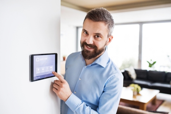 man pointing smart home thermostat screen
