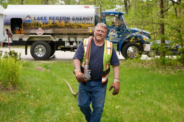 Glen, NH technician delivering heating oil with service truck in background