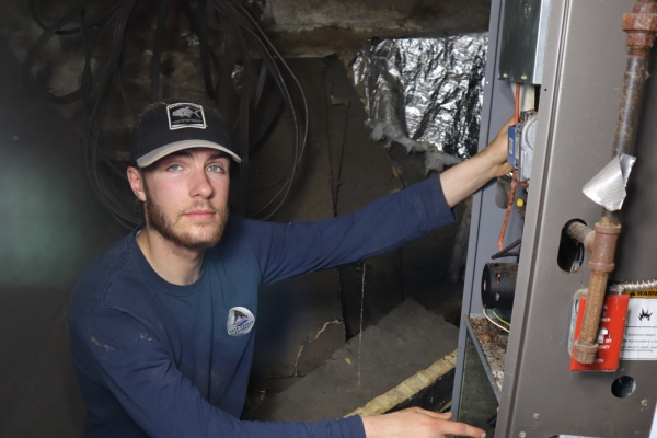 New Gloucester, ME hVAC technician performing maintenance on a furnace unit