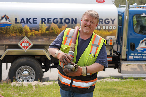 Glen, NH technician holding a fuel delivery hose near a service truck
